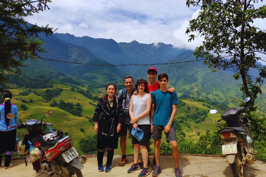 Family trekking in Sapa with scenic rice terraces and mountains in Vietnam